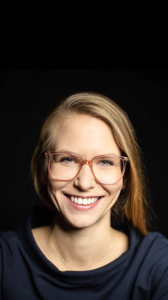 Someone smiling straight into the camera on a call